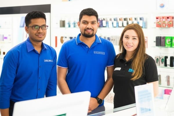 Equipe TecnoShop trabalhando em uma bancada com celulares